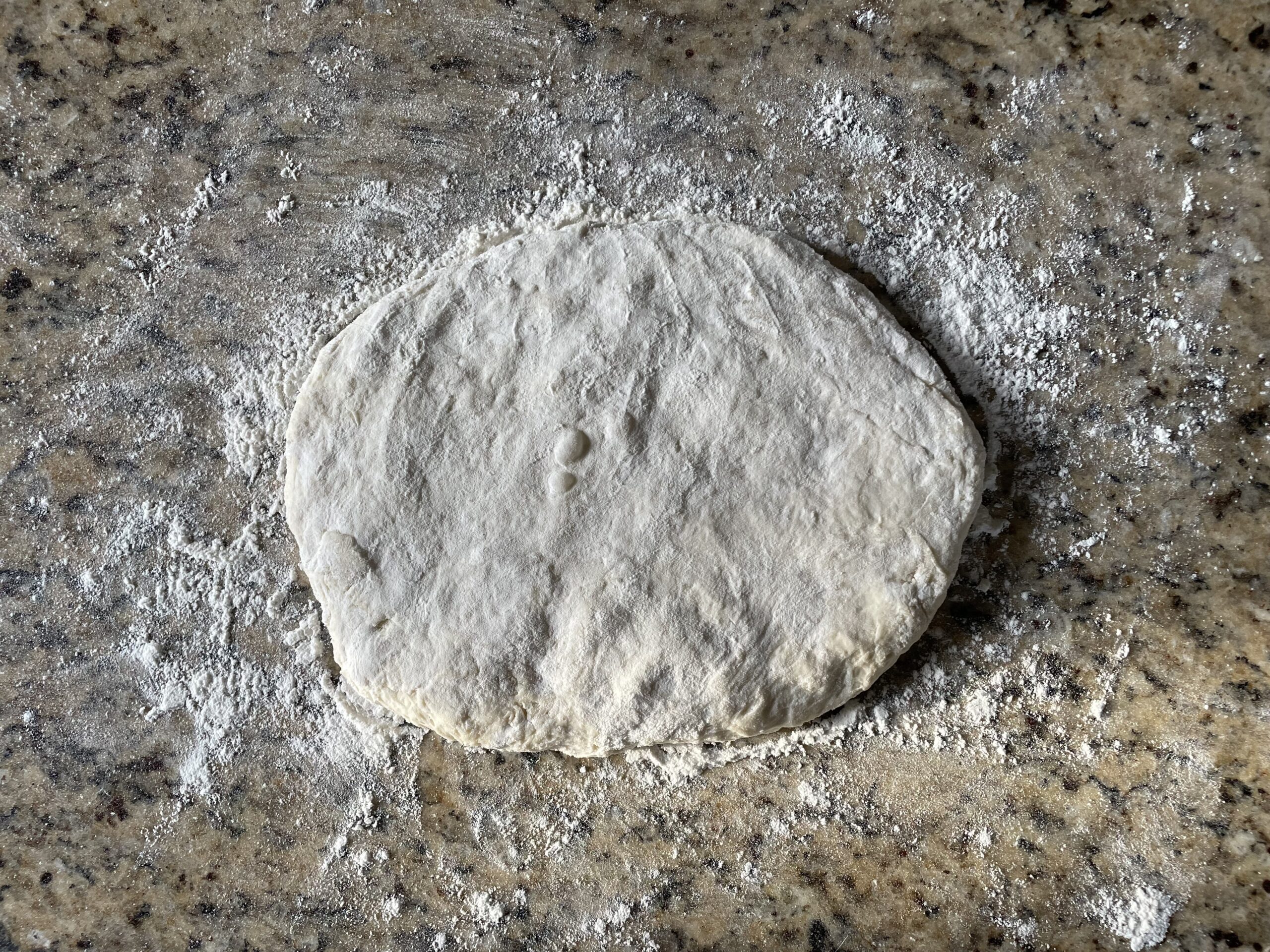 This photo shows the ball of dough flattened out ready to be cut