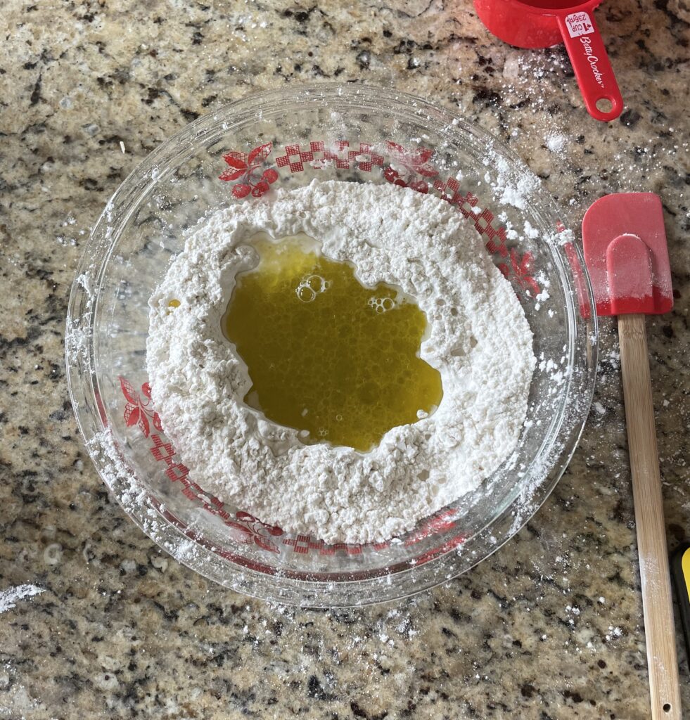 This image shows the wet ingredients added to the hole in the dry ingredients