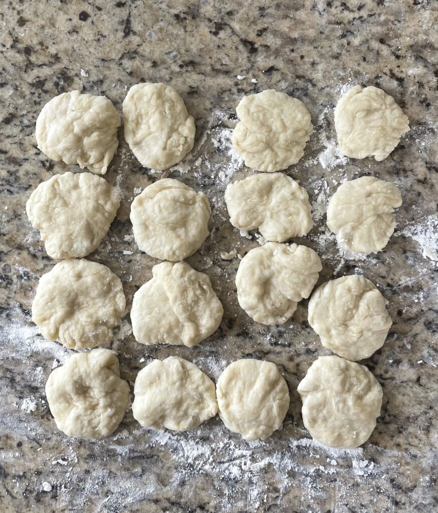 This image shows the dough rolled into balls and flattened with hands